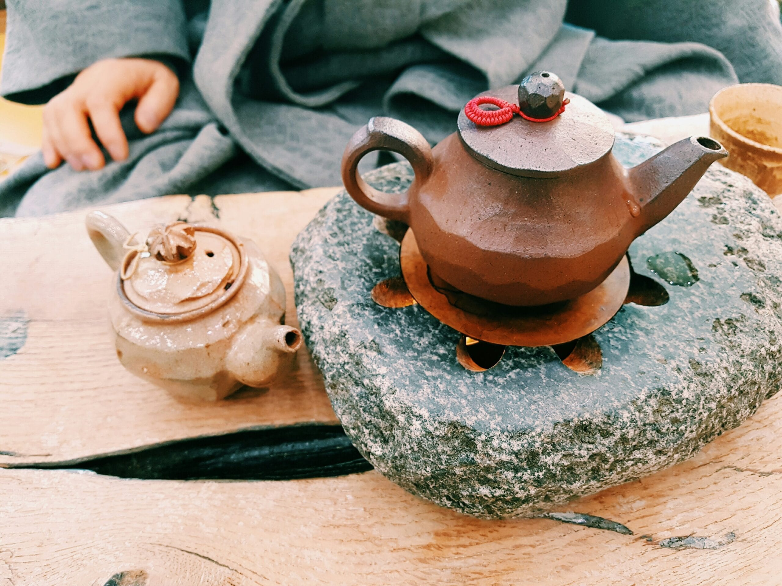 brown clay teapot on heated stone