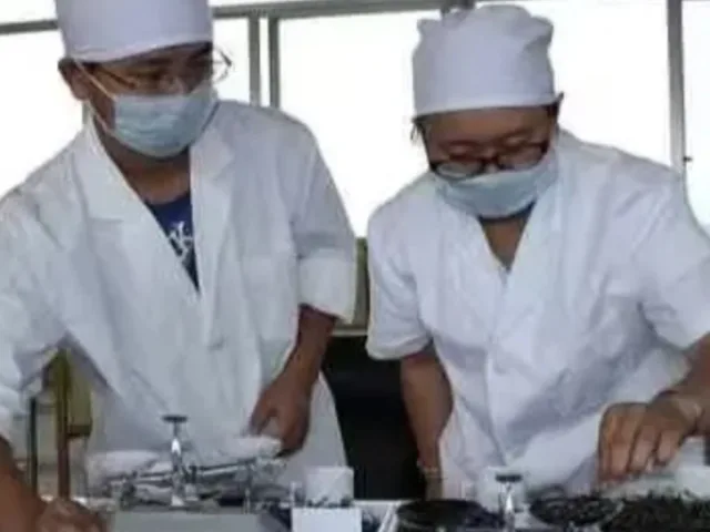 a couple of men wearing white coats and masks
